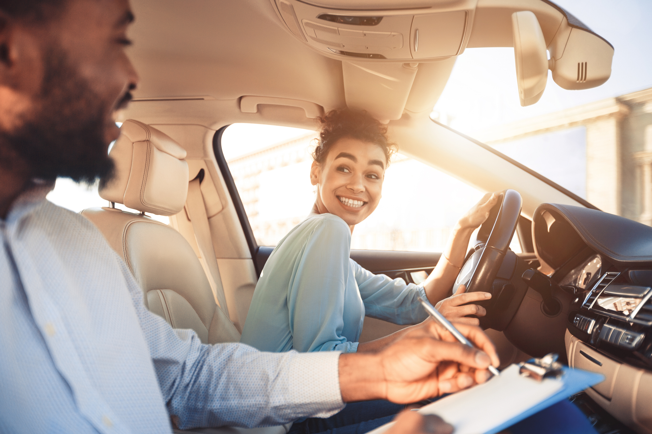 A teen student in a car with an instructor