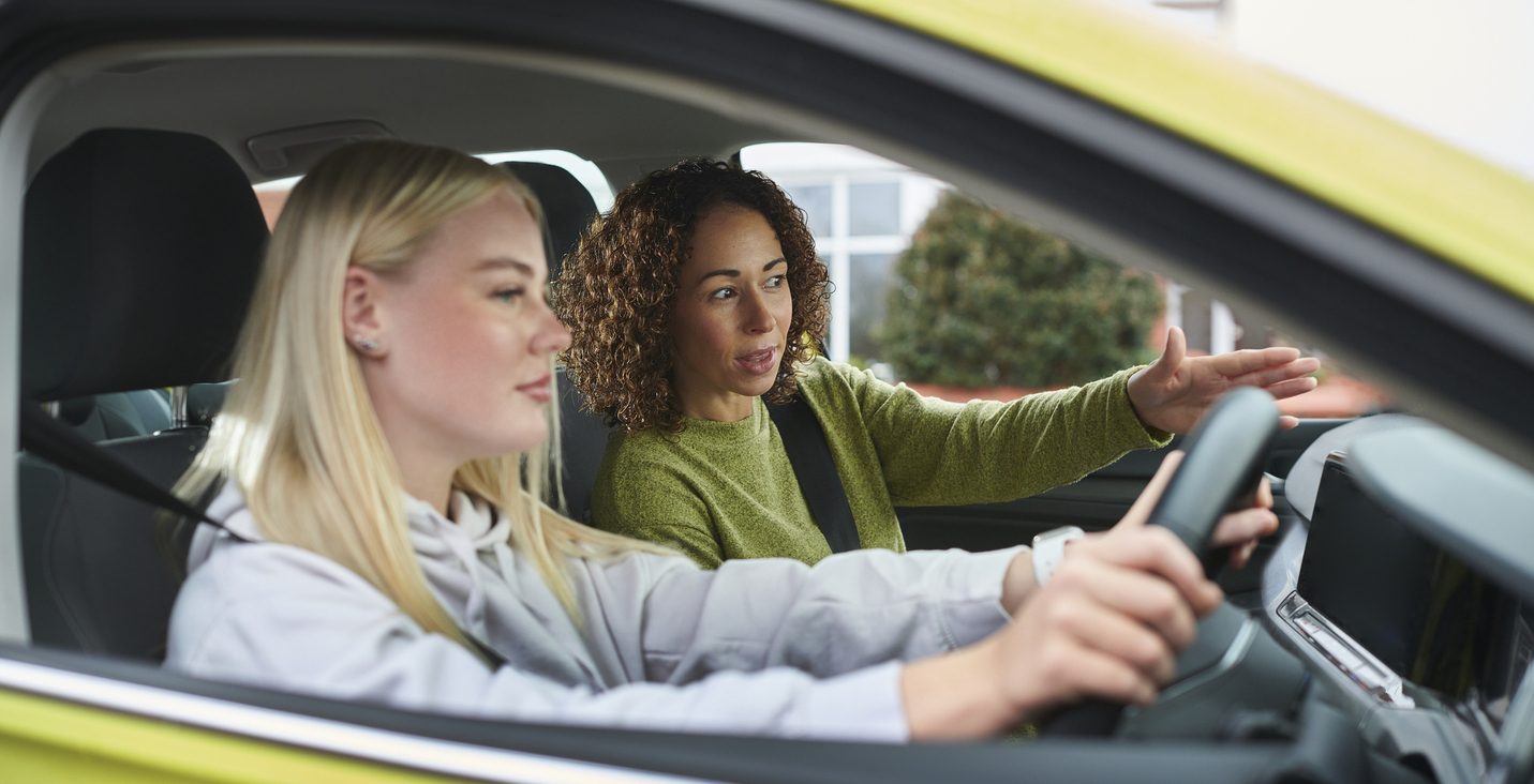 A girl behind the wheel with an instructor