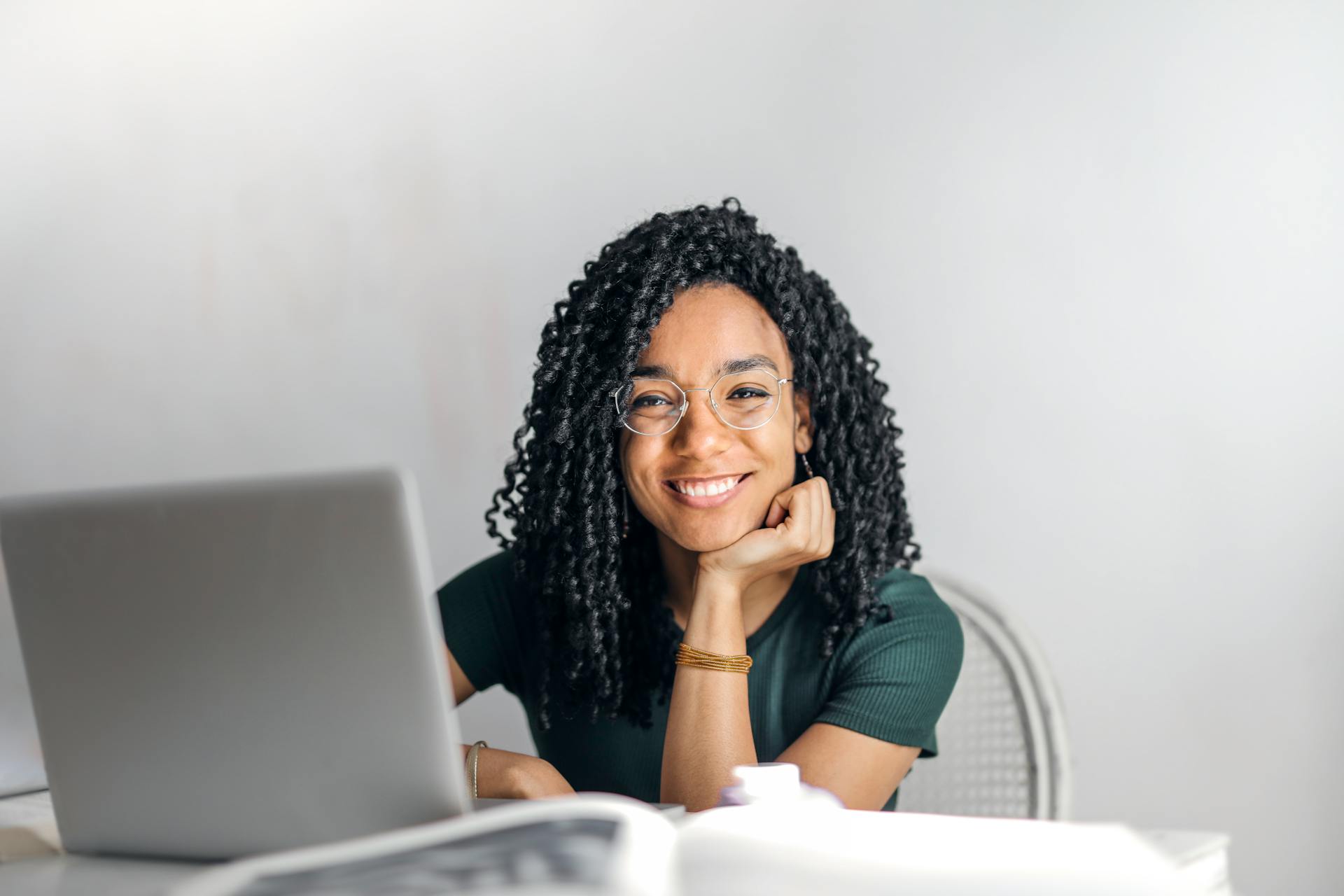 A girl sitting on a chair with a laptop on the table