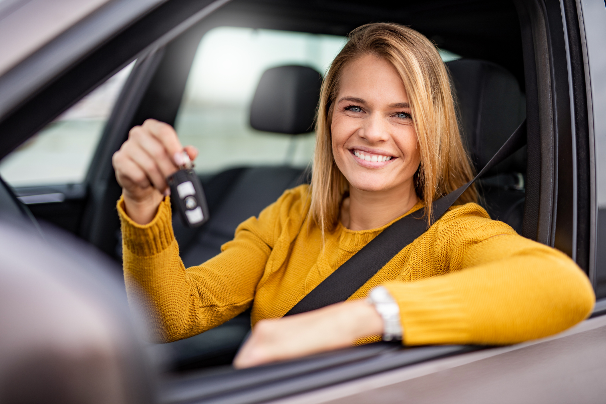 A girl behind the wheel showing car keys